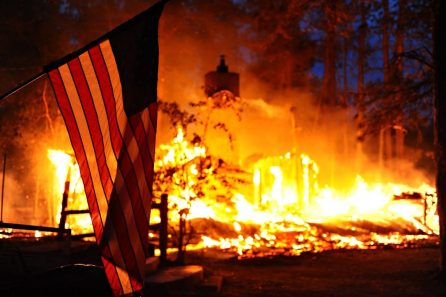 A U.S. flag hangs in front of a burning structure in Black Forest, Colo., June 12, 2013. The structure was among 360 homes that were destroyed in the first two days of the fire, which had spread to 15,000 acres by June 13. The Black Forest Fire started June 11, 2013, northeast of Colorado Springs, Colo., burning scores of homes and forcing large-scale evacuations. The Colorado National Guard and U.S. Air Force Reserve assisted in firefighting efforts. (DoD photo by Master Sgt. Christopher DeWitt, U.S. Air Force/Released)