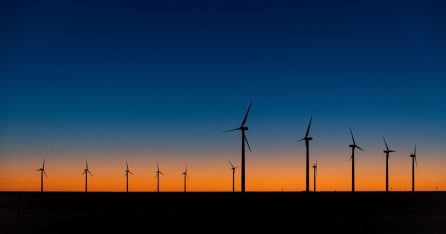A view of wind turbines against a dramatic sundown sky
