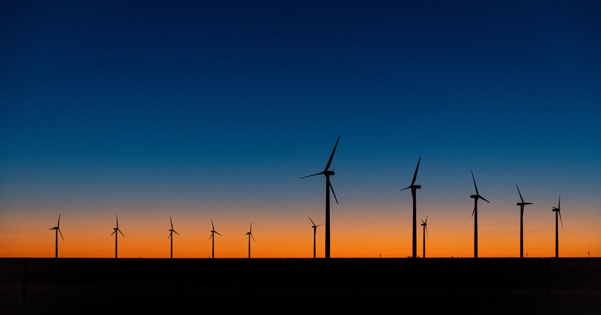 A view of wind turbines against a dramatic sundown sky